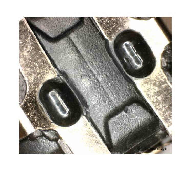 Ein Blech-Stanzteil wird durch einen heißverstemmten Pin in seiner Position fixiert.